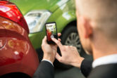 man taking pictures of car accident scene
