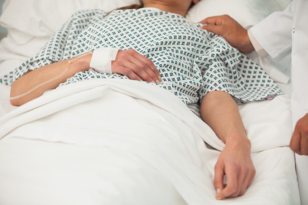 Patient lying in hospital bed.