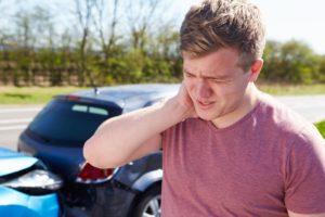 Man experiencing whiplash after car crash.