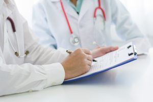 Doctors reviewing medical records of patient.