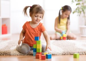 Little girl playing building blocks.