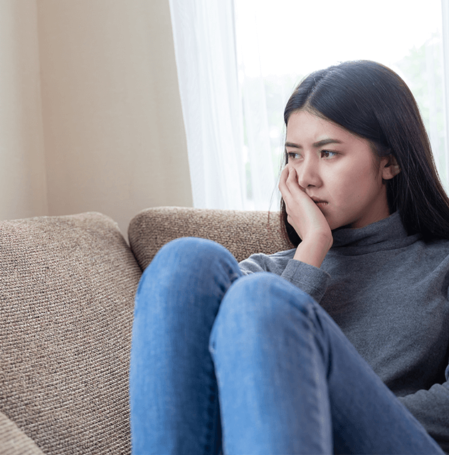 Photograph of sad women on a couch thinking